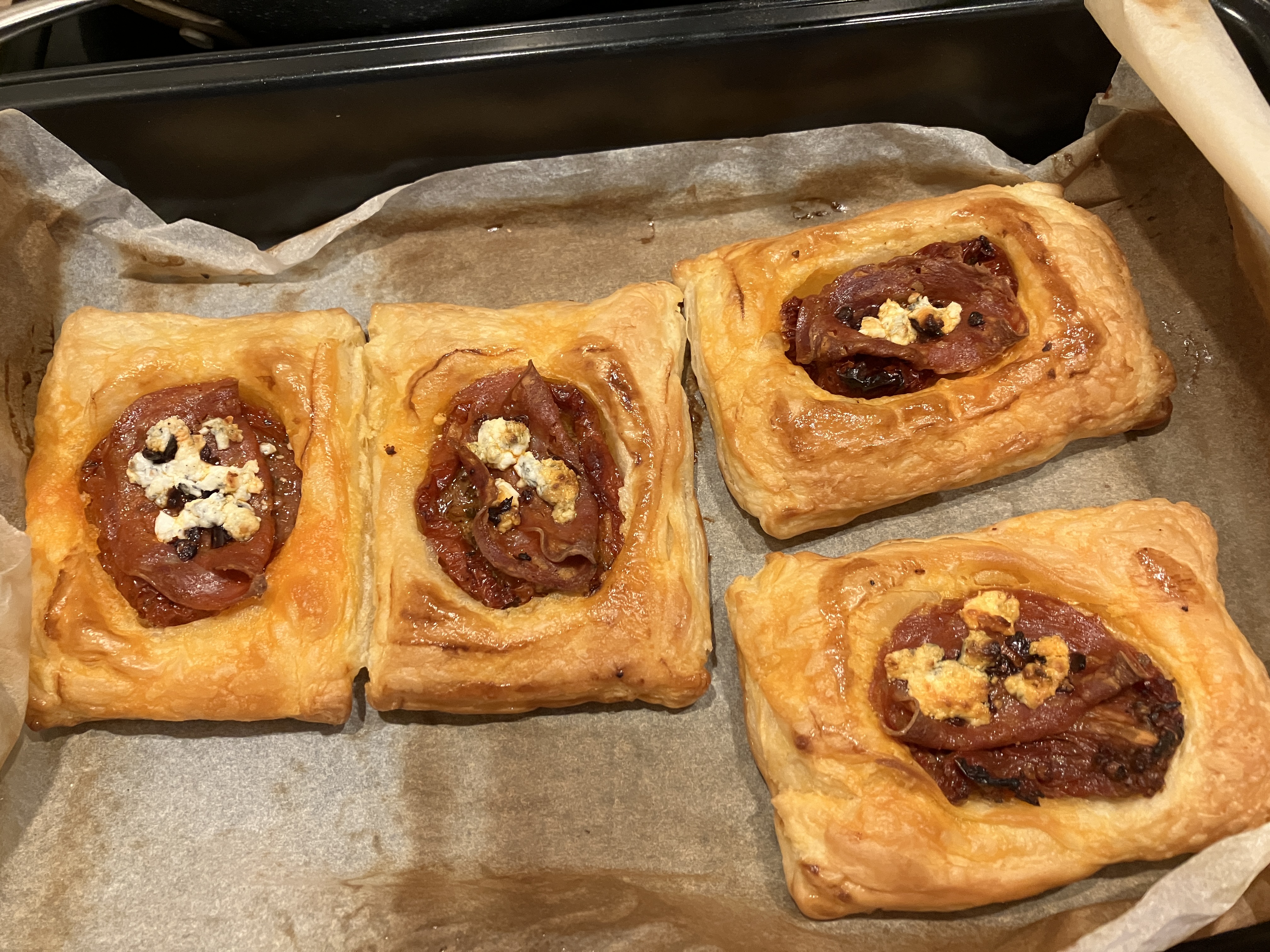 four of the same pastries on a sheet of baking paper four of the same pastries on a sheet of baking paper