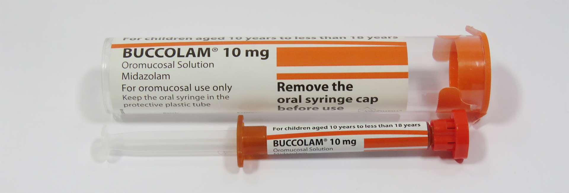 photo of buccolam 10mg oromucosal solution, a syringe with orange packaging and a red cap, with a protective tube cover around it. clickable link to leedsformulary.nhs.uk/docs/midazolamhowtoadministerbuccolam.pdf
